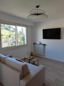 a living room with a couch and a flat screen tv at Appartement moderne refait à neuf - 4 couchages - MENTON in Menton