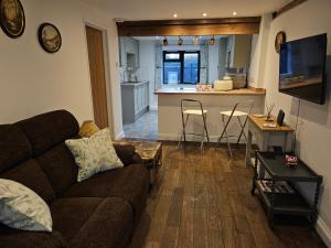 a living room with a couch and a kitchen at Middle Tree, ideal modern cottage in Alburgh