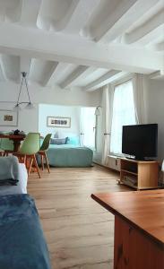 a living room with a flat screen tv and a bed at Boutique Fachwerkhaus Thirty Five in Monschau