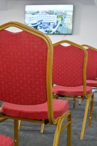 duas cadeiras vermelhas sentadas ao lado de uma mesa em Aquarius Hotel Boutique em Pampatar