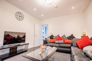 a living room with a couch and a tv at Guest Homes - Broadland House in Southampton