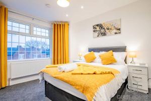 a bedroom with a large bed with yellow curtains at Guest Homes - Broadland House in Southampton