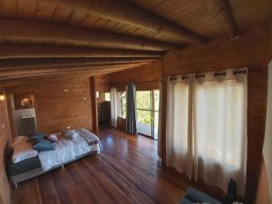 1 dormitorio con 1 cama y suelo de madera en Ecoverso Cabañas del bosque, en Medellín