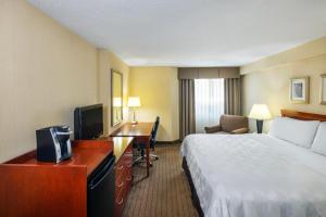 um quarto de hotel com uma cama e uma secretária em Holiday Inn Laval Montreal, an IHG Hotel em Laval