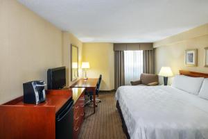 a hotel room with a bed and a desk at Holiday Inn Laval Montreal by IHG in Laval