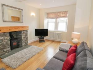 ein Wohnzimmer mit einem Sofa und einem Kamin in der Unterkunft Haven Cottage in Kirkcudbright