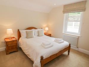une chambre avec un lit avec des serviettes dessus dans l'établissement Haven Cottage, à Kirkcudbright