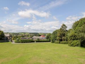 a large green field with houses in the distance at Haven Cottage in Kirkcudbright