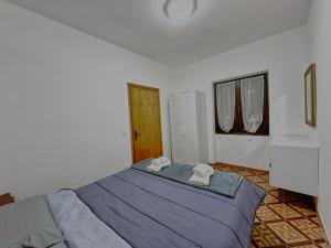 a bedroom with a bed with two towels on it at residenza piccolo diamante a 300m dal centro in Borno