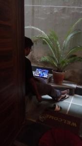 a man sitting on a table with a laptop at Sanjana's stay in Udaipur