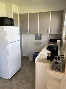 a kitchen with white cabinets and a white refrigerator at Rolo Beach Hotel in Fort Lauderdale