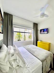 a bedroom with a white bed and a window at Casa Irauna in Sao Paulo