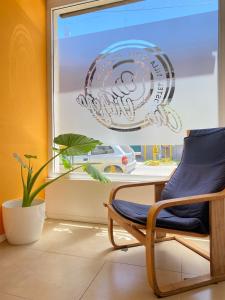 een stoel voor een raam met een bord bij Hostel Che Viajero in Villa Gesell
