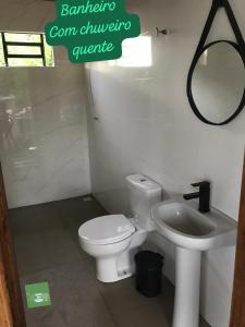a bathroom with a white toilet and a sink at Refugio Verde Zen in Dois Vizinhos