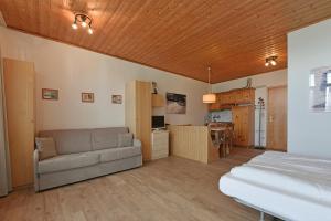 a living room with a couch and a kitchen at Appartaments Alpi in Seiser Alm 