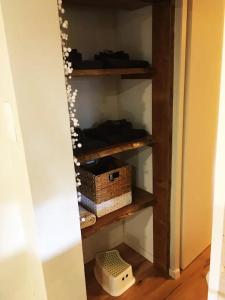 une étagère dans une pièce avec un panier et une boîte dans l'établissement Joli Appartement Cosy 2 à 4 pers avec terrasse La Fourmi, à Orbey