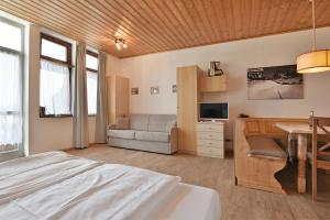- une chambre avec un lit, un canapé et une table dans l'établissement Appartaments Alpi, à Seiser Alm