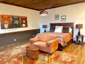 a bedroom with a bed and a couch and a chair at The Dogwood Inn in Blue Ridge