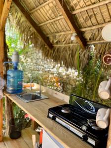 a kitchen counter with a stove and a sink at Casita de Madera Encuentro in Bombita