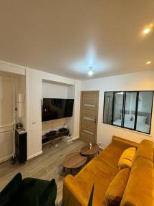 a living room with a couch and a television at Appartement moderne au centre-ville in Saint-Denis