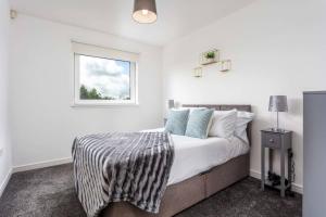 a white bedroom with a bed and a window at Walker Suite No 60 - Donnini Apartments in Kilmarnock