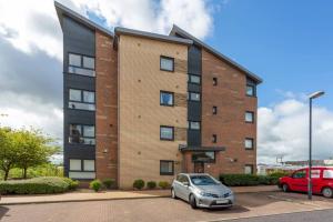 an apartment building with a car parked in a parking lot at Walker Suite No 60 - Donnini Apartments in Kilmarnock