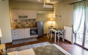 a kitchen and dining room with a table and a refrigerator at MARON ΙΙ με τζάκι in Kalavrita