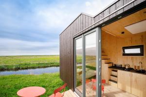 a house with a view of a river at Tiny House Nature 14 Zur Meerseite - Green Tiny Village Harlesiel in Carolinensiel