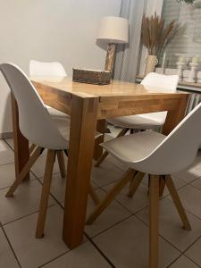 einem Holztisch mit zwei weißen Stühlen und einem Tisch mit einer Lampe in der Unterkunft Strandstern Norddeich in Norddeich