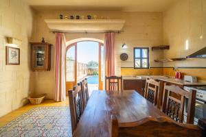 cocina con mesa de madera y ventana grande en 3 Bedroom Holiday Home with Large Private Pool and Views, en Xewkija