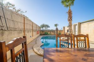 un patio con mesa y sillas y una piscina en 3 Bedroom Holiday Home with Large Private Pool and Views, en Xewkija