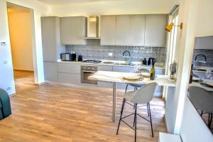 a kitchen with white cabinets and a table and chairs at VUEL SEA VIEW HOUSE -10 Minutes from the Airport Fiumicino in Fiumicino