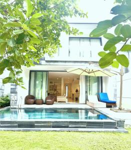 a villa with a swimming pool in front of a house at "BRG GOLF CLUB" - Danang Private Pool Villa 3 Bedrooms #2 in Danang