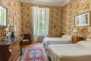 a bedroom with two beds and a dresser and two windows at Maison d'hôtes - Villa Les Pins - Lempaut in Lempaut