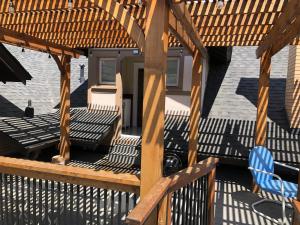 a wooden pergola with a table and chairs on a deck at Knight Campbell Carriage House in Denver