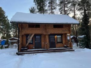 una cabaña de madera con nieve encima en Villa Kalajärvi, en Seinäjoki