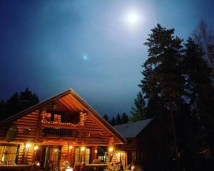 una cabaña de madera por la noche con la luna en el cielo en Villa Kalajärvi, en Seinäjoki