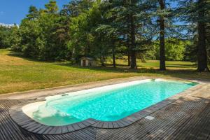 an empty swimming pool on a deck with trees in the background at Maison d'hôtes - Villa Les Pins - Lempaut in Lempaut