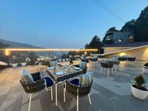 a patio with tables and chairs on a roof at ARNISA Kasauli - A Boutique Hotel in Kasauli