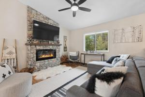 a living room with a couch and a fireplace at Open Sky Retreat - Close to Trails, Private Hot Tub, Big Yard, & Kid Friendly in Whitefish