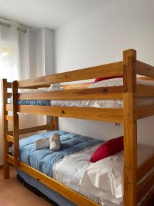 dwa łóżka piętrowe z pluszowym misiem na dolnym łóżku w obiekcie APARTAMENTO PLANTA BAJA CANET DE BERENGUER w mieście Canet de Berenguer