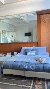 a bedroom with a large bed with a wooden headboard at Regina del Porto in Brindisi