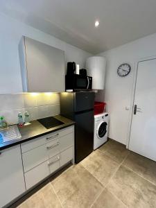 uma cozinha com um frigorífico preto e uma máquina de lavar roupa em Maisonnette 2 pers tout confort près de Paris em Bobigny