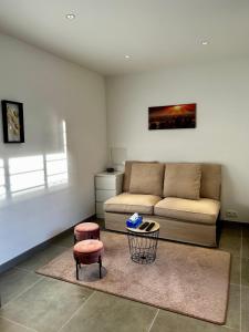 sala de estar con sofá y 2 taburetes en Maisonnette 2 pers tout confort près de Paris en Bobigny