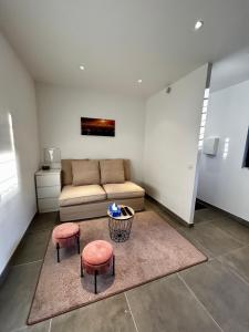 a living room with a couch and two stools at Maisonnette 2 pers tout confort près de Paris in Bobigny