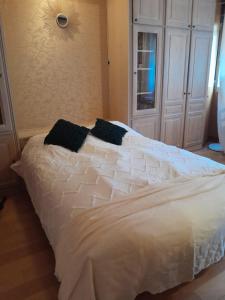 a white bed with black pillows in a bedroom at Arc de triomphe studio charme authentique in Paris