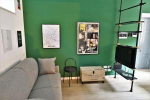 - un salon avec un canapé et un mur vert dans l'établissement Bergamo tra alta e bassa: ST apartments, à Bergame