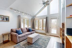 a living room with a couch and some windows at Hibernation Station in Thornton