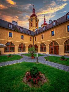 ヘイニツェにあるKlášter Hejnice - vzdělávací, konferenční a poutní důmの時計塔のある大きな建物