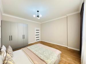 a bedroom with white cabinets and a bed in it at Nexpo City 2-Room Apartments in Astana